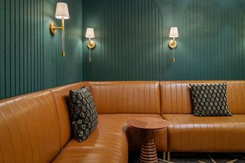 Lounge seating with tan leather sofa and green paneled walls